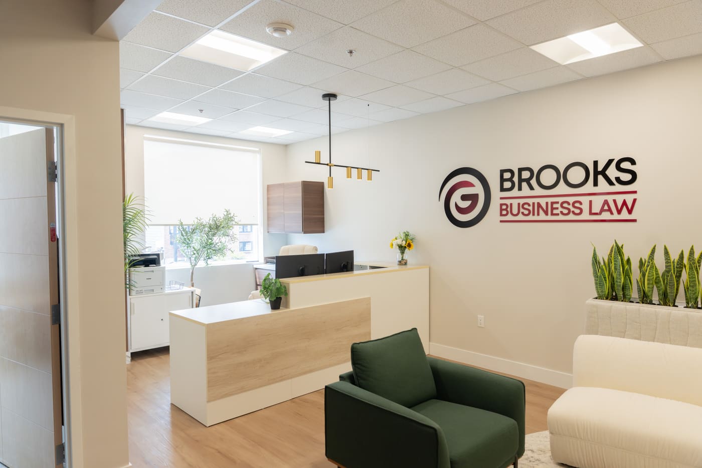 The reception desk at Brooks Business Law with the firm's name on the wall behind it.