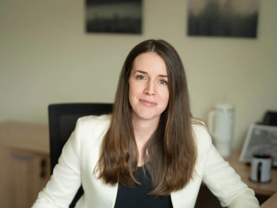 Amanda Smith Hatt in a white jacket, seated at her desk.