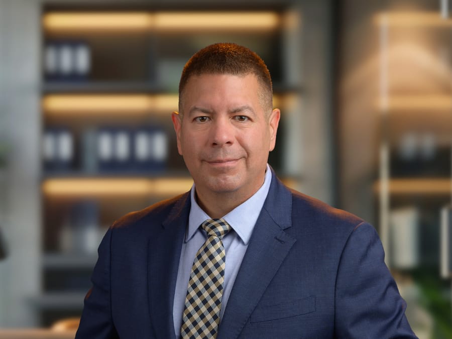 Garnet Brooks in a navy suit and checked tie.