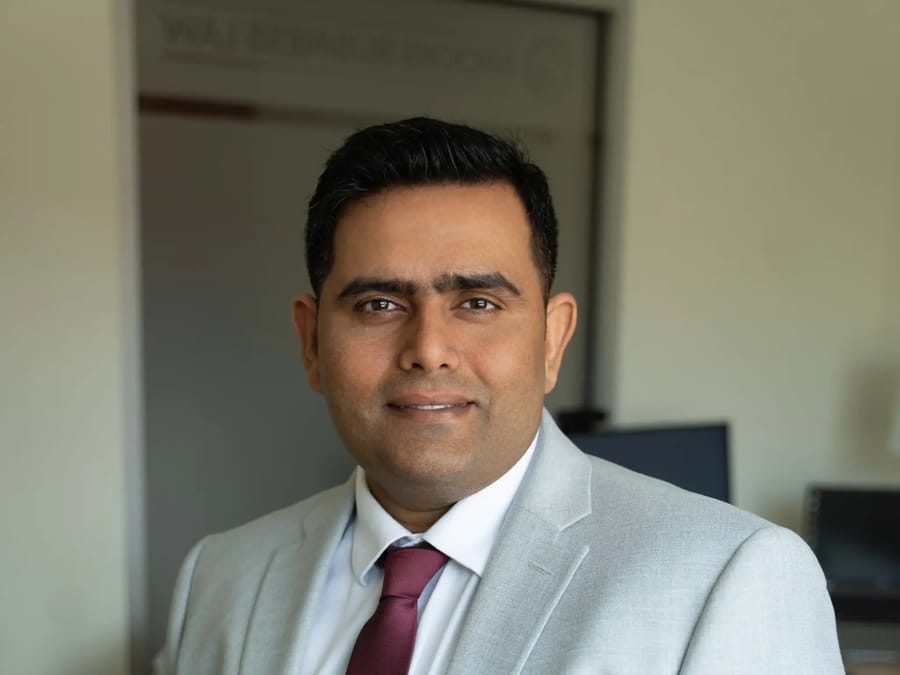 Shashank Roheria in a pale grey suit and burgundy tie.